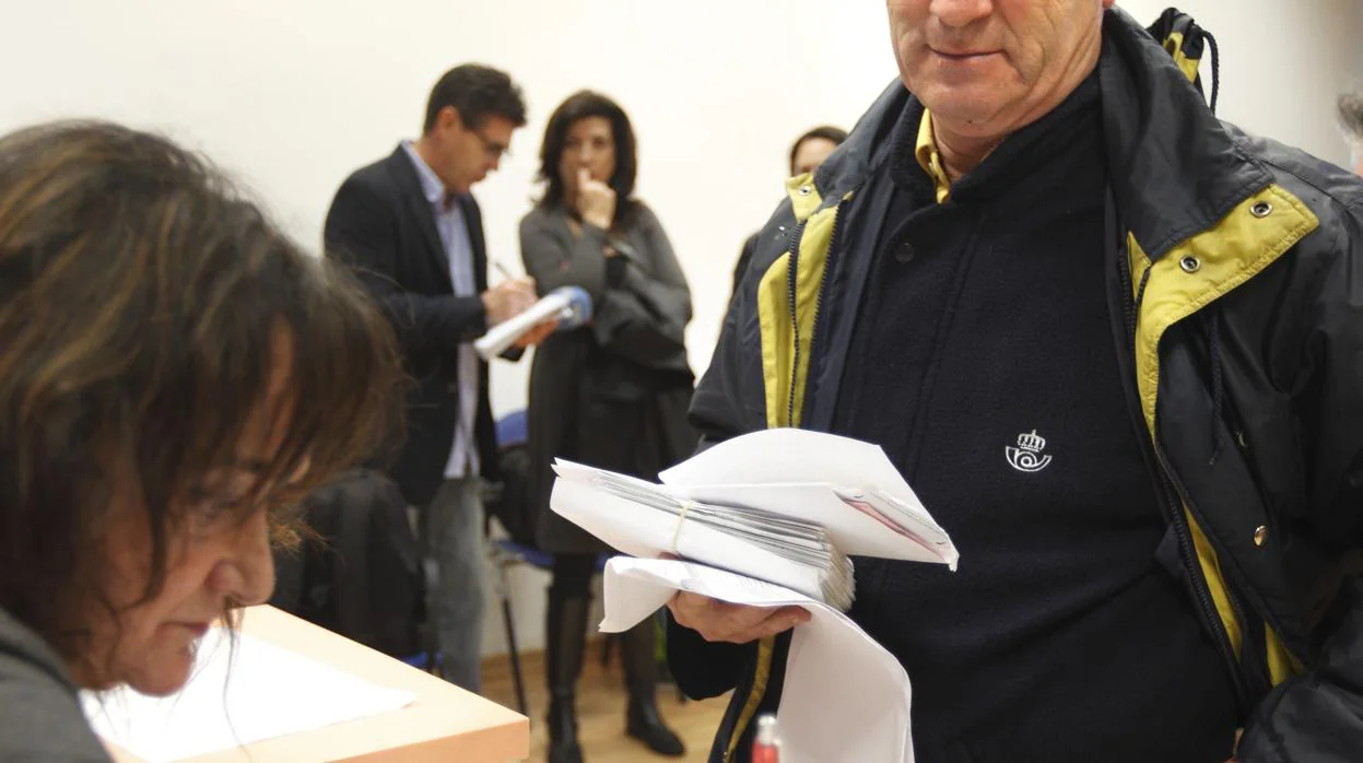 Un funcionario de Correos entrega el voto por correo en un colegio electoral valenciano