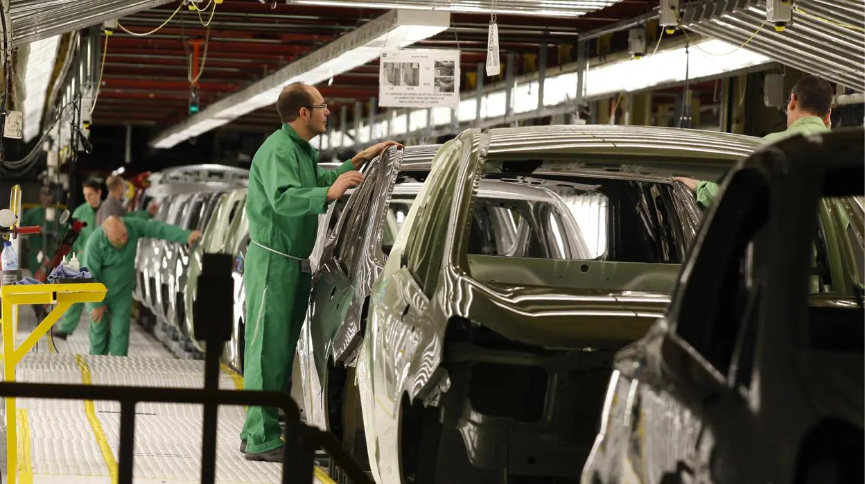 Operarios en una cadena de montaje de la factoría de Opel en Figueruelas (Zaragoza)