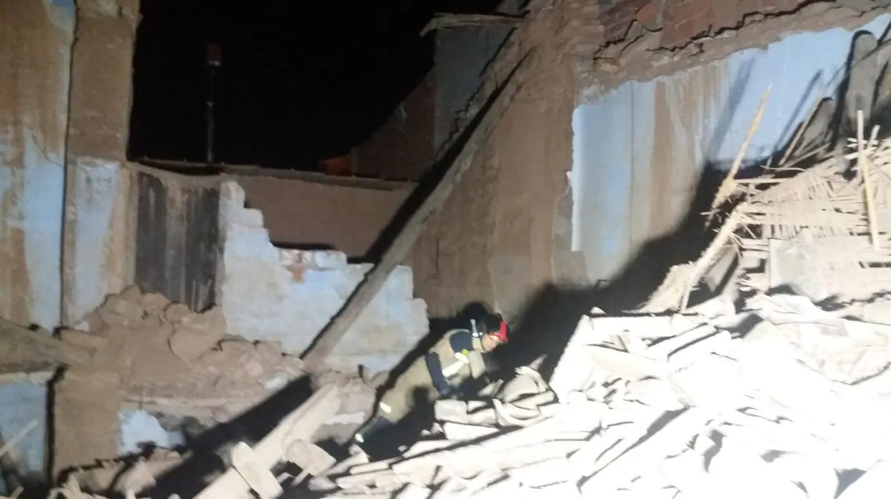 Un bombero, sobre los restos de la vivienda que quedó reducida a escombros