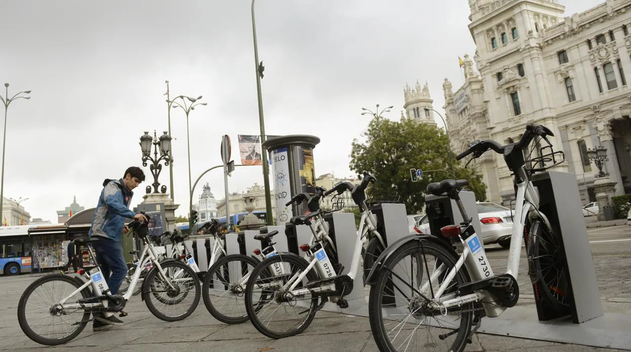 Un usuario de Bicimad recoge una bicicleta frente al Palacio de Cibeles