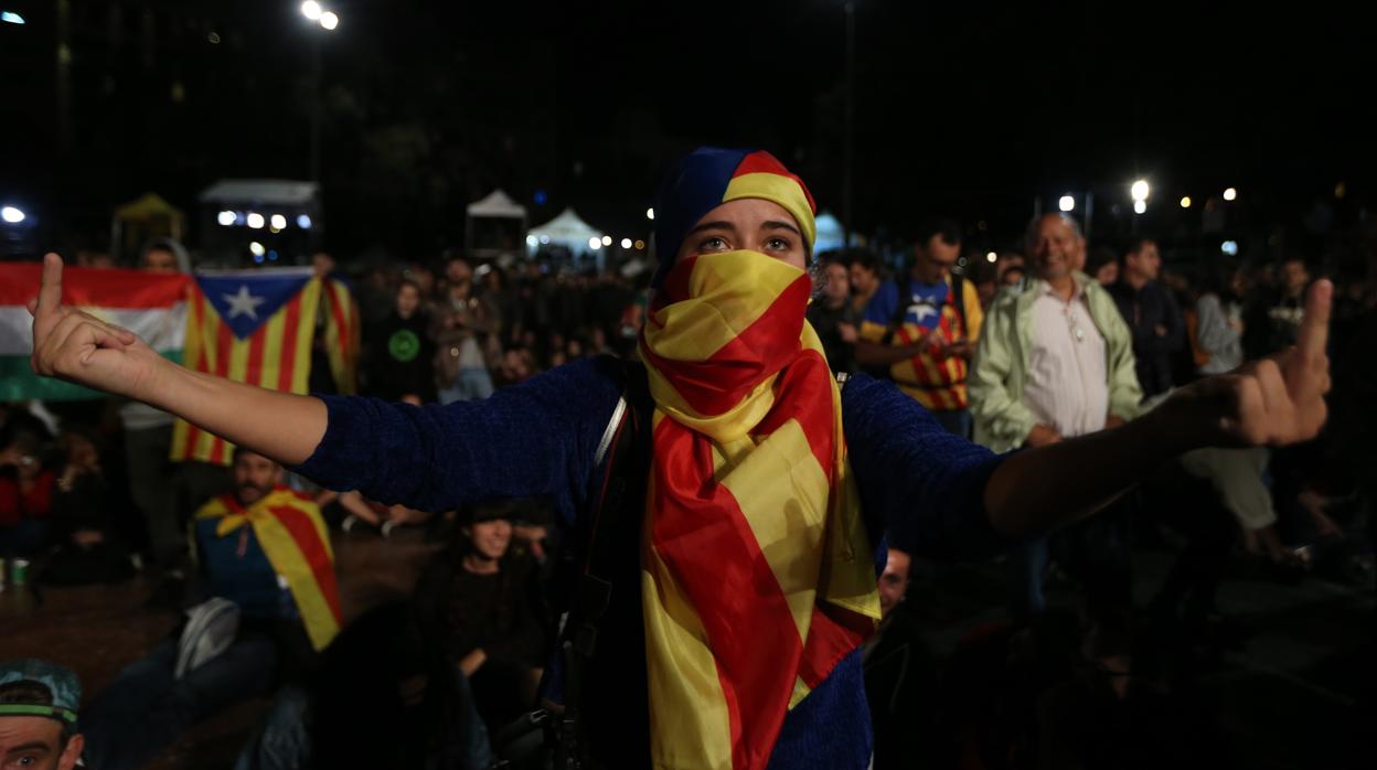 Una independentista insulta a España en la jornada del 1-O, mientras oculta su rostro con una «estelada»