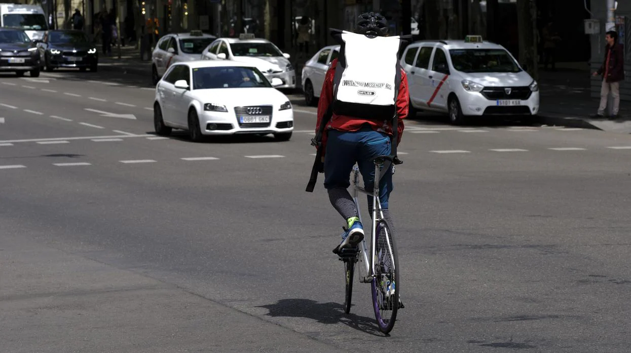 Un «rider» circula con su bicicleta por una calle de Madrid