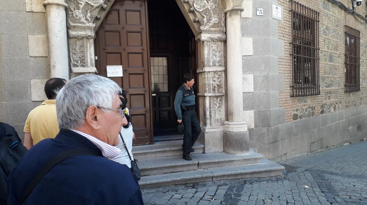 Domingo, de espaldas, delante de la puerta de la Audiencia Provincial de Toledo este martes