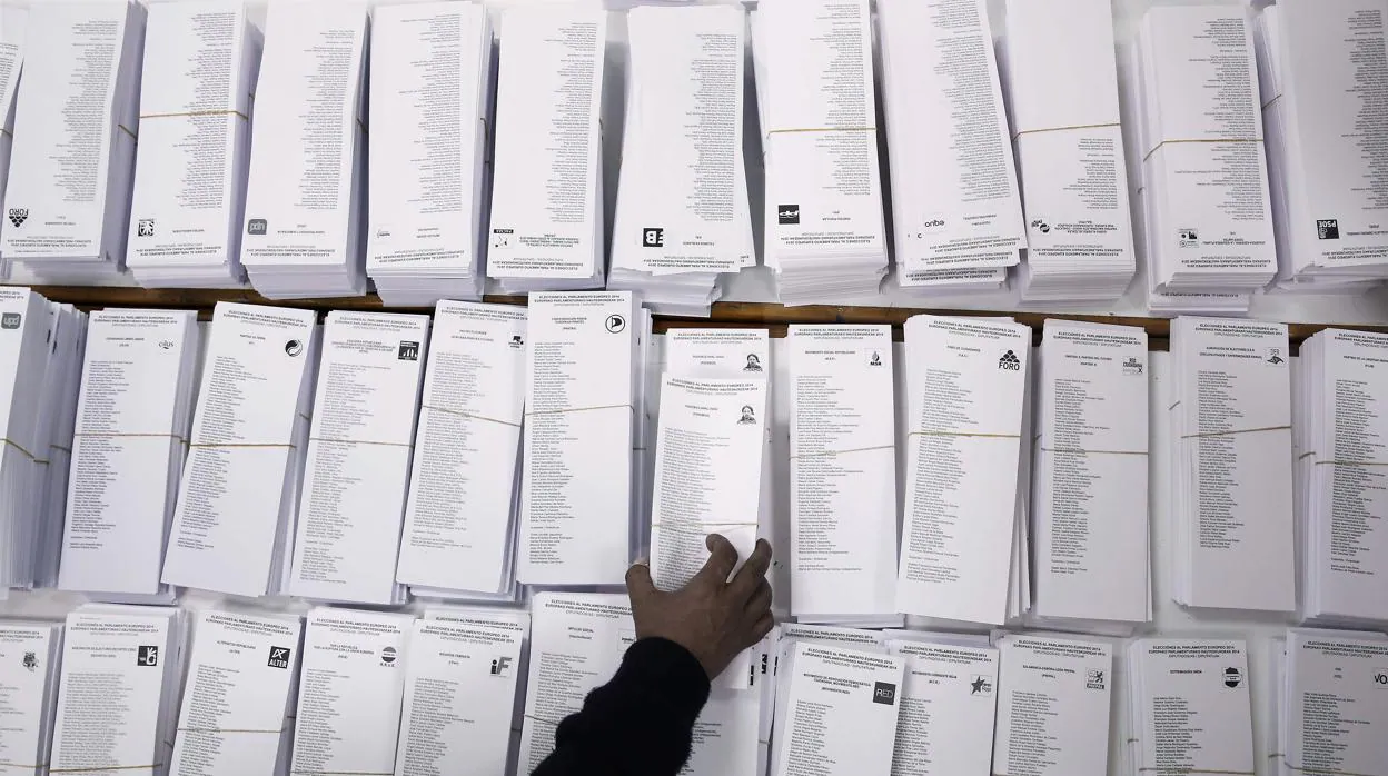 Un votante toma una papeleta en un colegio electoral