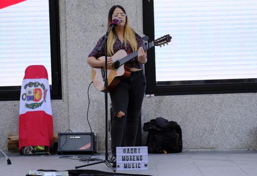 Adriana Moreno canta con su guitarra y el cartel promocional