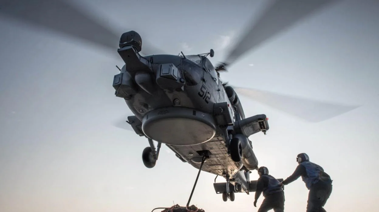 Un helicóptero despega con carga desde el destructor USS Jason Dunham