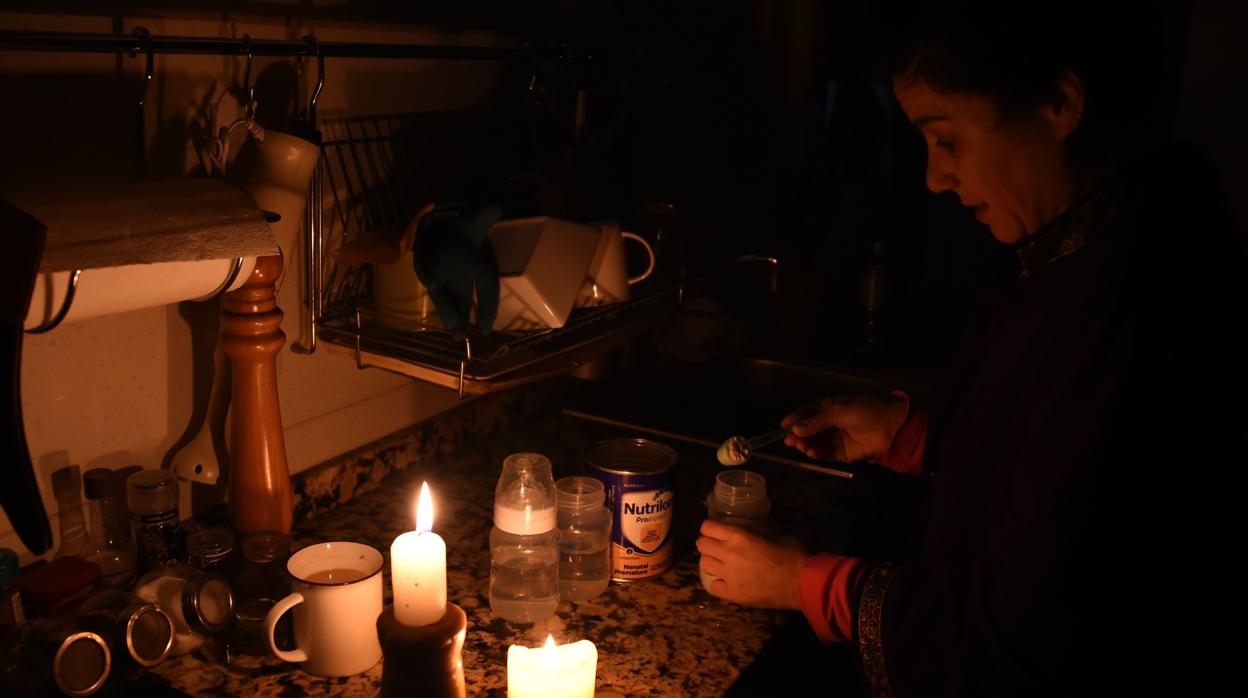 Una mujer prepara un biberón en Buenos Aires durante el apagón, Argentina