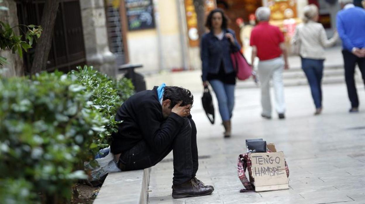 Un mendigo pide limosna en las calles de Valencia