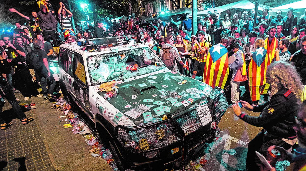 Un coche de la Guardia Civil, destrozado durante el asedio a la Consejería de Economía catalana el 20-S de 2017