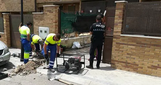 Un agente da seguridad, el 4 de julio, a los trabajadores municipales que cortan el suministro de agua a una vivienda okupada