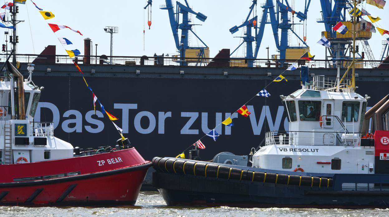 Imagen de un remolque de Boluda Towage junto a un barco