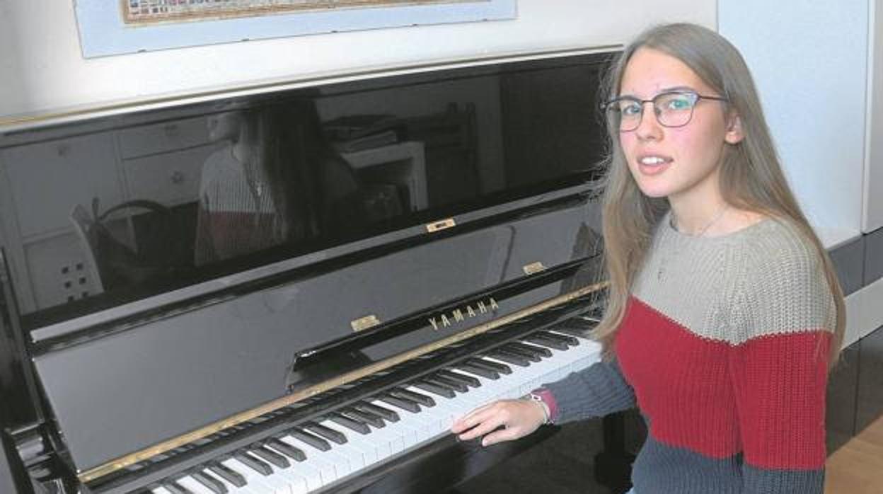 Inés sentada al piano de su casa de La Coruña,