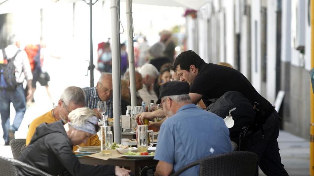 Un camarero atiende la terraza de un negocio de restauración en Santiago