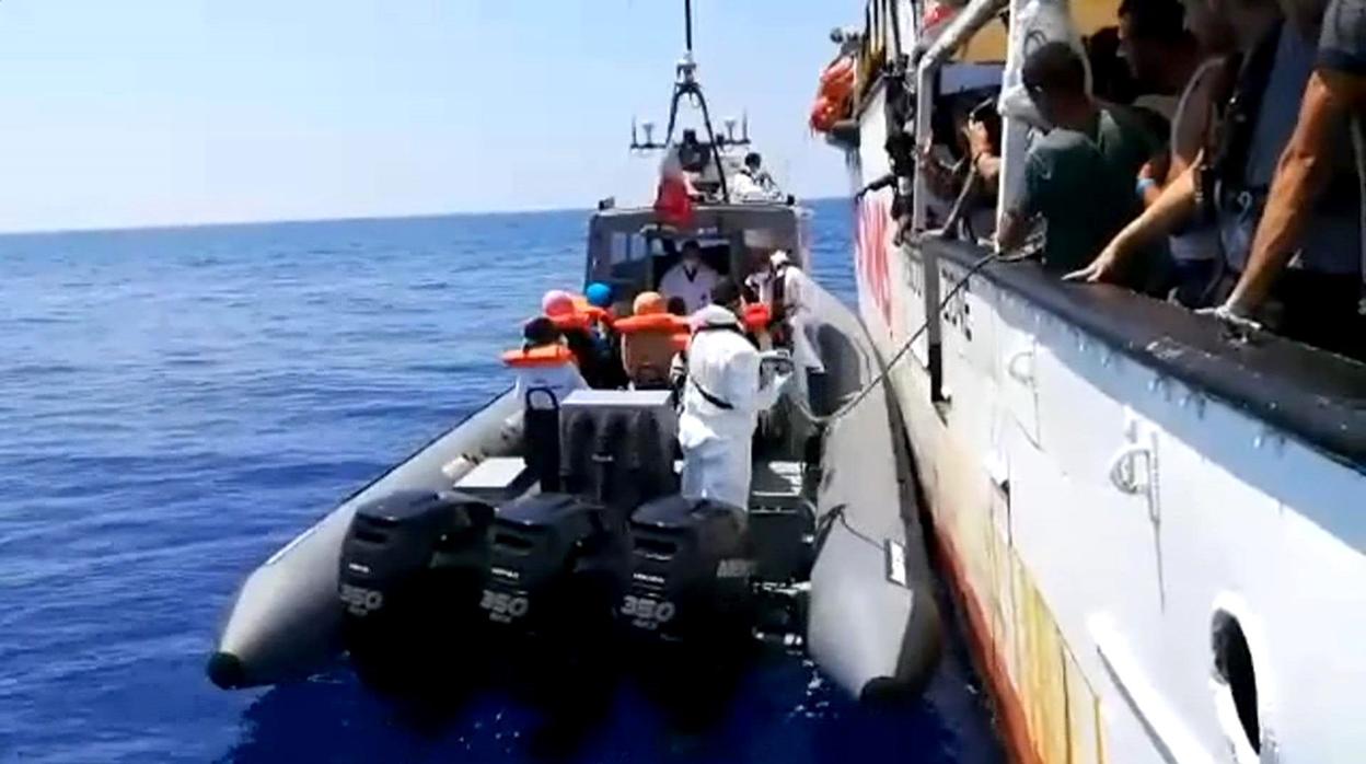 Imagen tomada de un vídeo facilitado por Open Arms del momento en que varios inmigrantes son evacuados hoy desde el barco de la ONG española Open Arms, que espera un puerto seguro en el que poner a salvo a unos 150 inmigrantes rescatados en aguas del Mediterráneo central