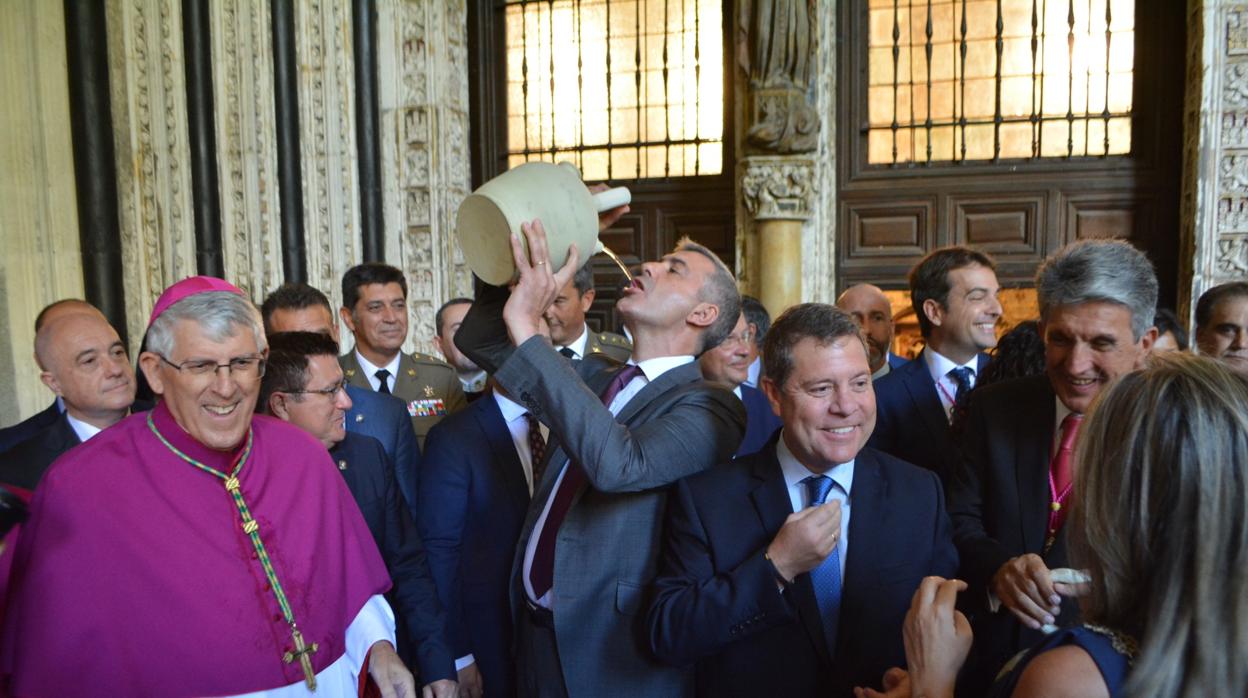 El arzobispo de Toledo sontríe en el claustro de la catredral junto a Page y Tolón mientras Gutiérez bebe del botijo