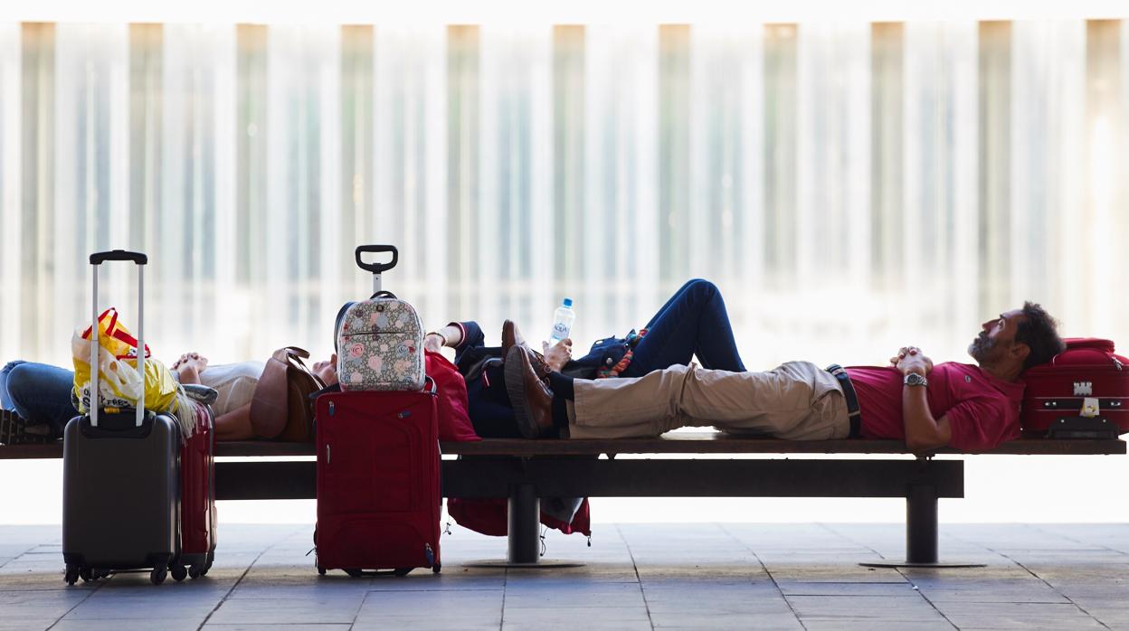 Algunos pasajeros descansan en la segunda jornada de huelga de los trabajadores de tierra de Iberia en el aeropuerto de Barcelona-El Prat