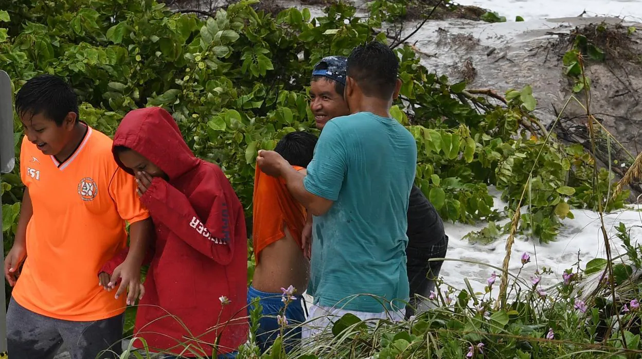 Unos niños se alejan luego de ser golpeados por las olas que causa el huracán Dorian, en Bahamas