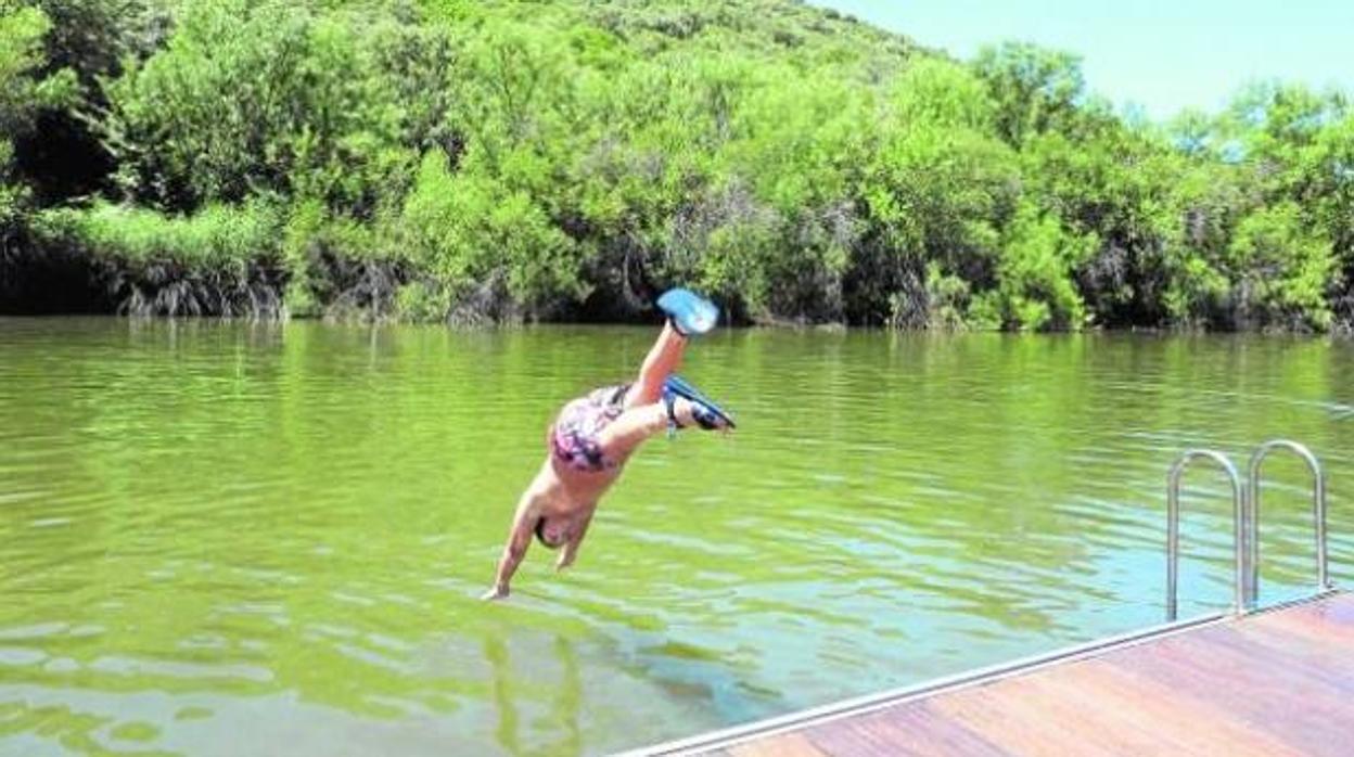 Un bañista, en pleno salto, para sumergirse en una de las piscinas naturales de Castilla-La Mancha