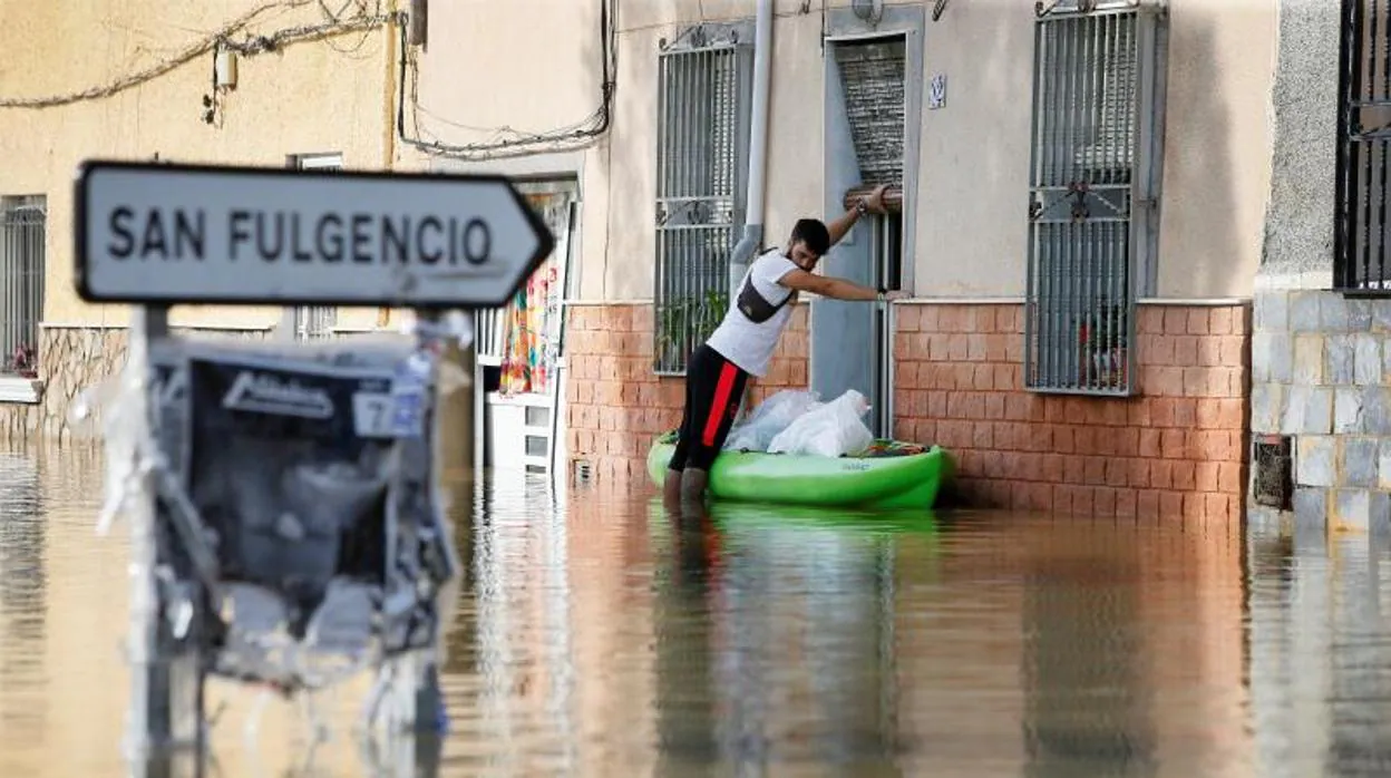 Un vecino de Dolores transporta efectos personales en una canoa desde su casa inundada