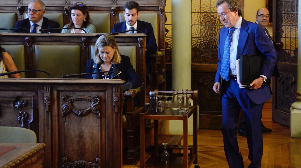 El concejal del PP en el Ayuntamiento de Valladolid, José Antonio de Santiago-Juárez (d), a su llegada al pleno celebrado este martes en Valladolid, donde se debate la moción del Grupo Popular para reconocer la ciudad como capital de la Comunidad, entre otros asuntos