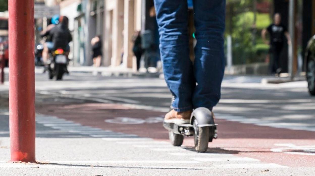 Detalle de un usuario que va en patinete por un carril bici de Barcelona