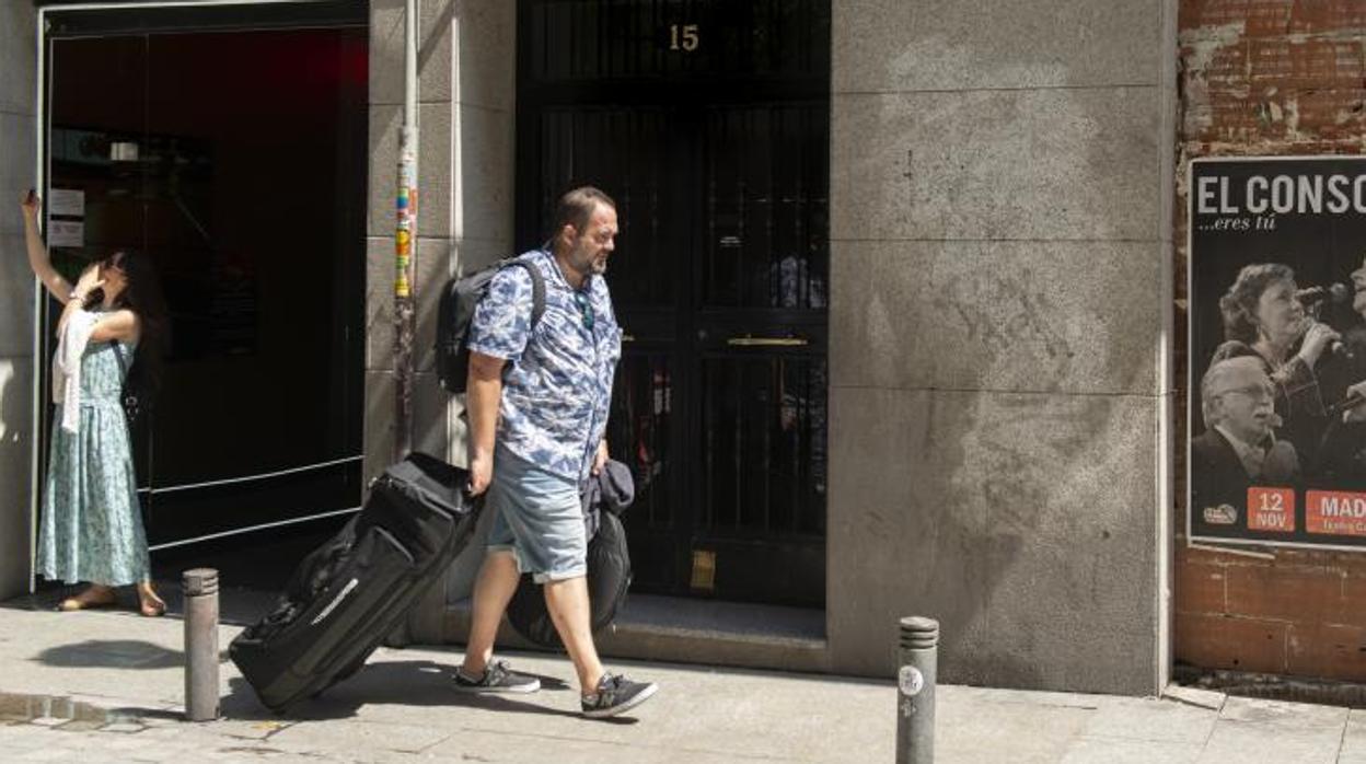 Un turista pasea con su maleta por delante del número 15 de la calle del Príncipe