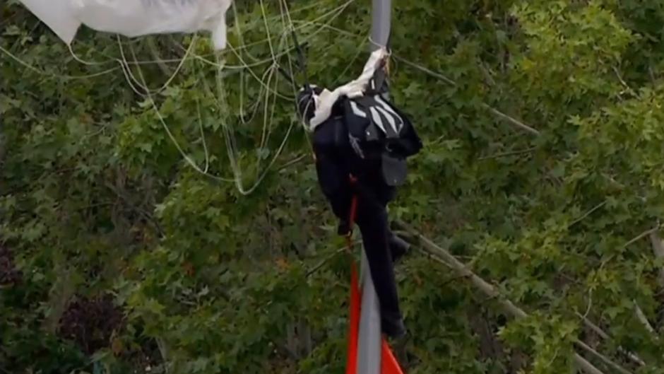 Vídeo: El paracaidista que portaba la bandera se queda enganchado en una farola