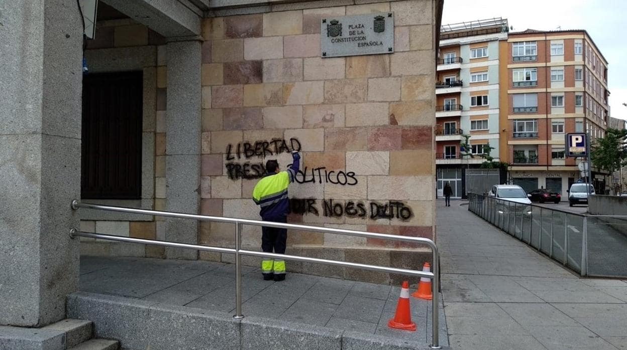 Un operario trata de borrar las pintadas a las puertas del edificio de la Subdelegación del Gobierno, en Zamora