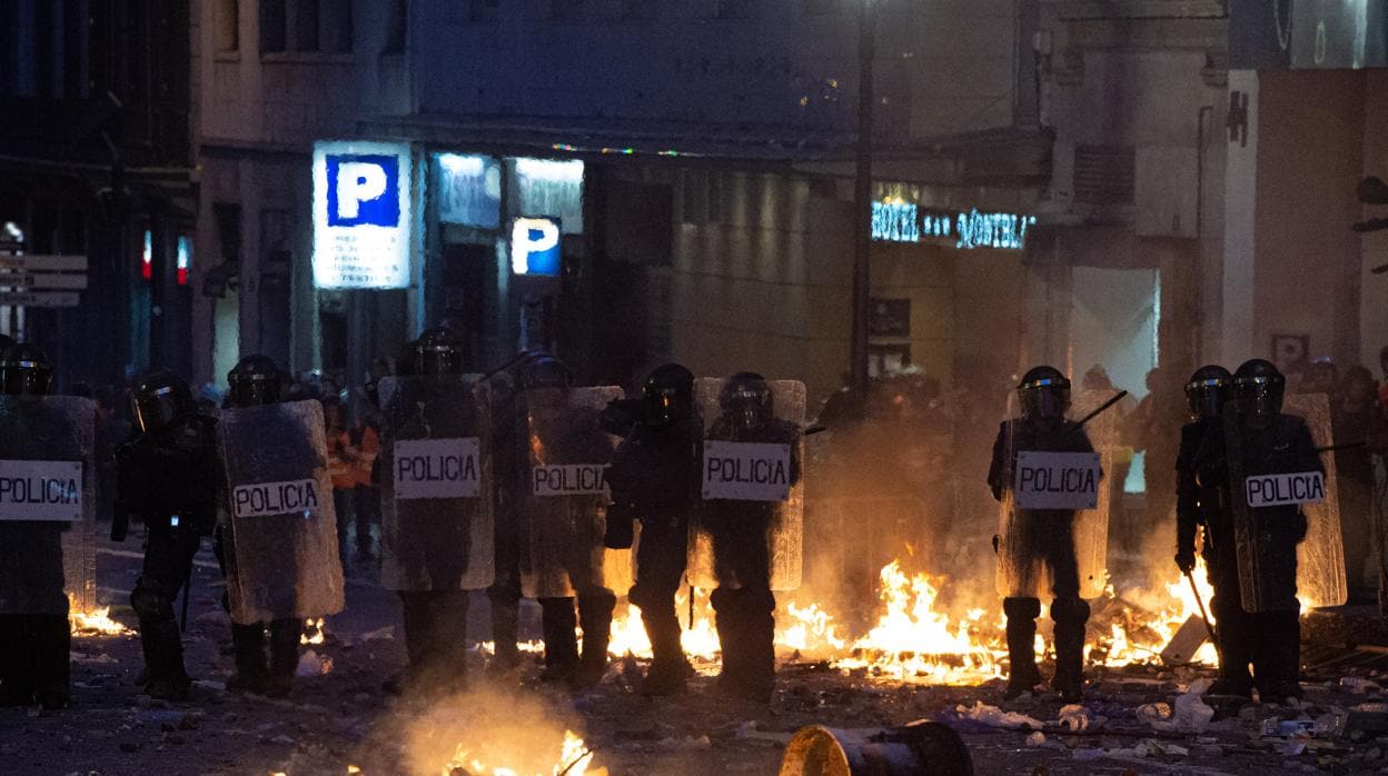 Agentes ante una de las barricadas montadas por los radicales en el centro de Barcelona