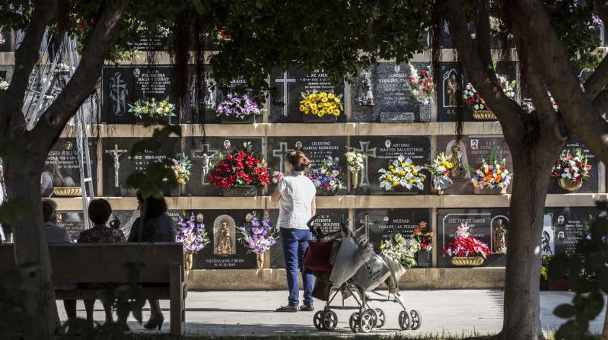 Varias personas visistando a sus difuntos en el cementerio de Valencia