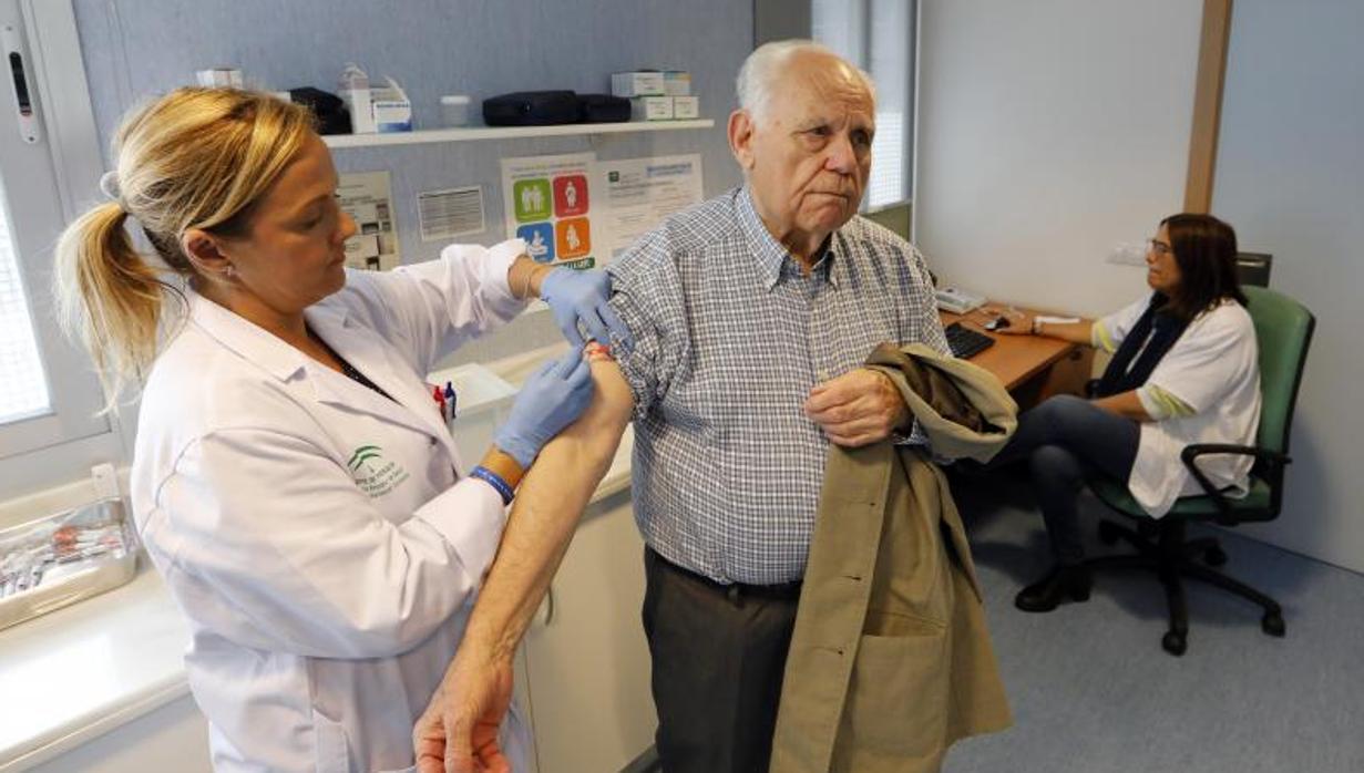 Una enfermera vacuna a un anciano durante la campaña de vacunación de la gripe