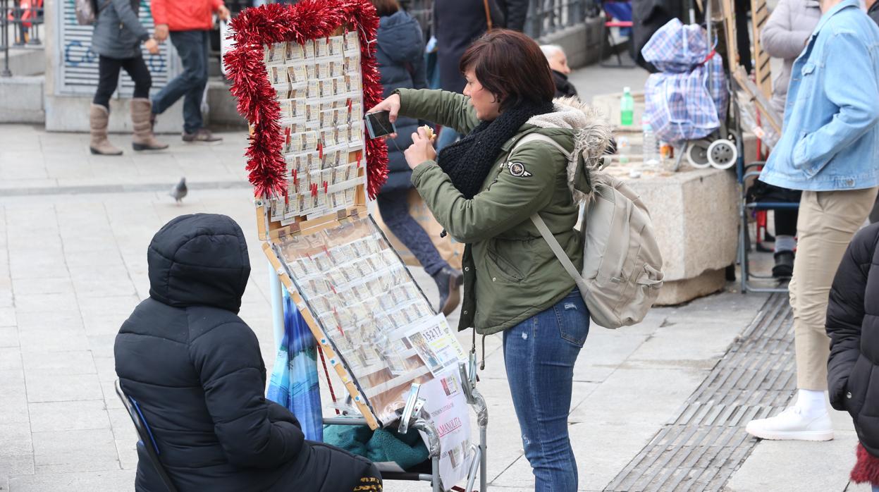 Un caballete con décimos de la lotería de Navidad en la puerta del Sol