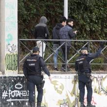 Dos agentes vigilan a tres jóvenes