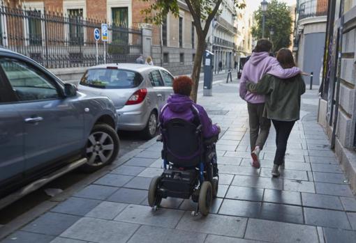 Una mujer se desplaza en silla de ruedas por la calle del Barquillo, en Centro, donde se mejorará la accesibilidad