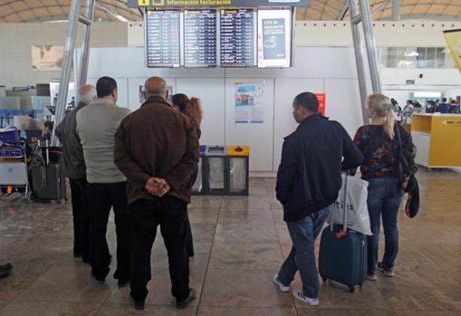 Pasajeros consultando los horarios de los vuelos, este jueves tras la reapertura de la terminal