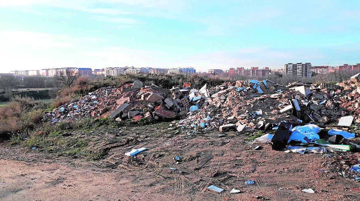 Montañas de escombros en el camino del Malecón, frente a viviendas en Villaverde