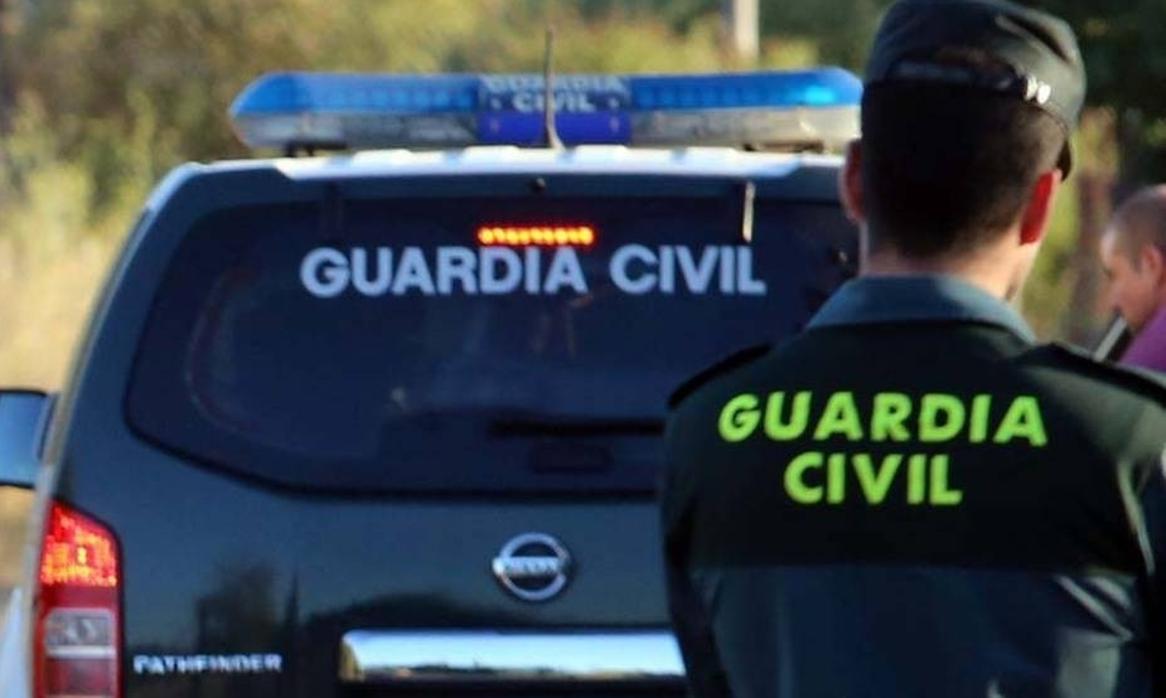 Un agente de la Guardia Civil, con su vehículo en la carretera