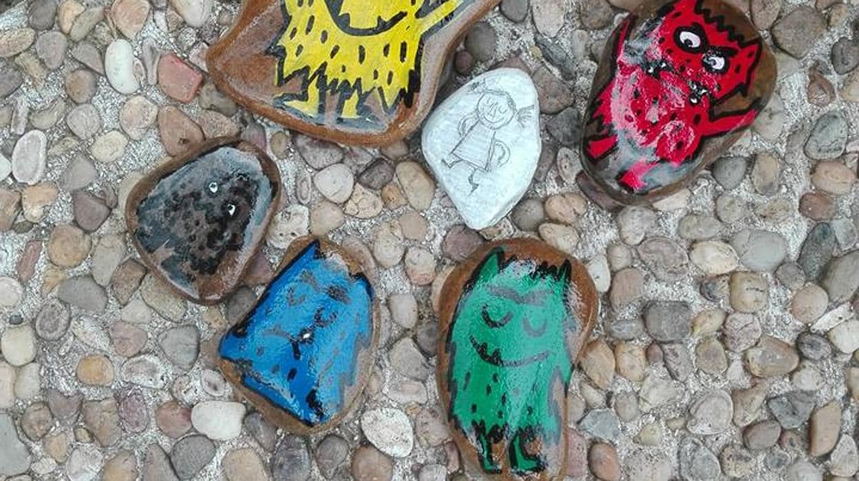 Piedras pintadas con motivos del cuento «El monstruo de colores» escondidas por uno de los miembros del grupo