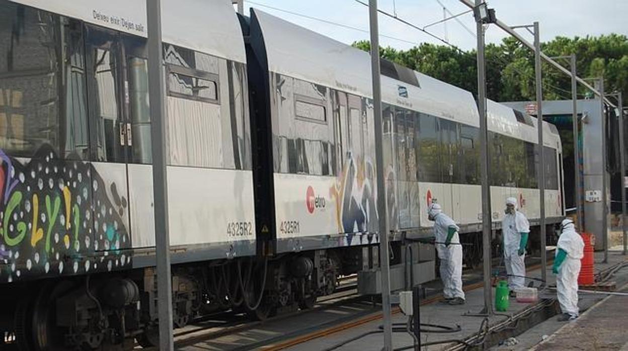 Operarios de Metrovalencia limpiando grafitis en los vagones