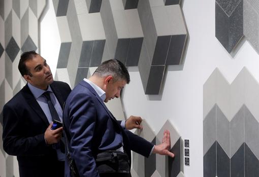 Imagen de dos personas tocando una pared en la feria Cevisama