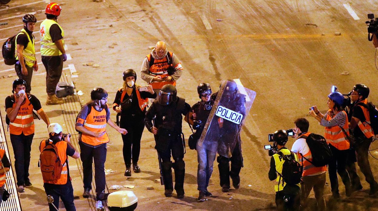 Dos policías detienen al fotoperiodista de El Pais Albert García durante los altercados ocurridos en Barcelona tras la sentencia del «procés»