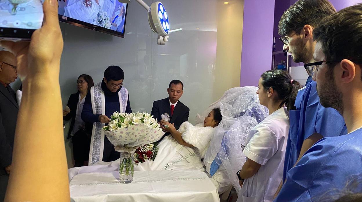 La pareja, en el momento de casarse, rodeados de invitados y médicos