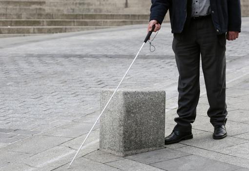 Carlos muestra cómo su bastón no detecta un dado de granito en la calle de la Paz