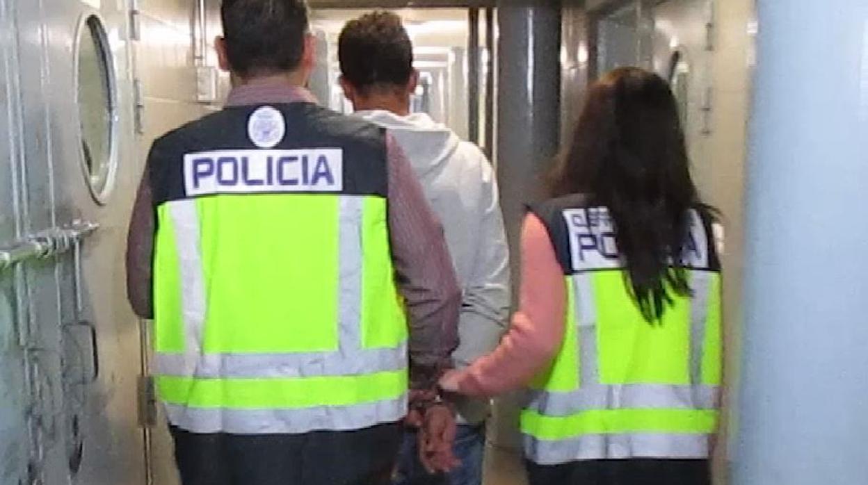 Dos agentes de Policía Nacional conducen al detenido por las dependencias policiales