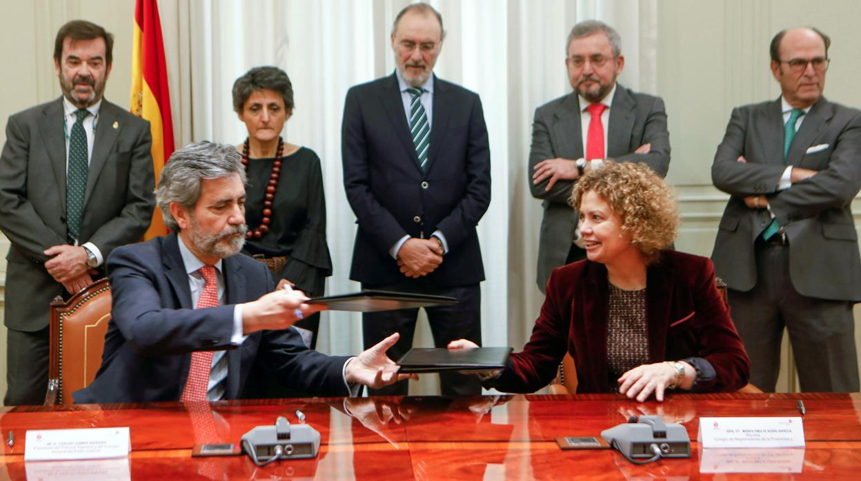 El presidente del Tribunal Supremo y el Consejo General del Poder Judicial, Carlos Lesmes, y la presidenta del Colegio de Registradores, María Emilia Adán, durante la firma del convenio