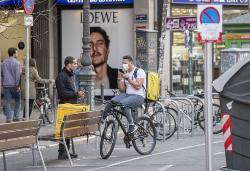 Imagen de un «rider» con mascarilla por el centro de Valencia