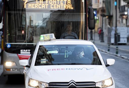 Imagen de un taxi y un autobús por una calle Colón vacía tomada este sábado