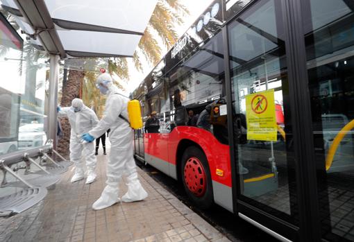 Imagen de miembros de la Unidad Militar de Emergencias (UME) desinfectando una parada de autobús en Valencia