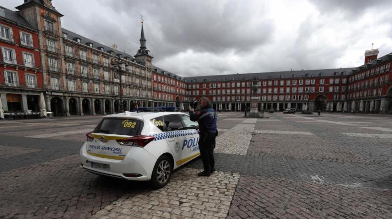 Una patrulla de la Policía Municipal vigila que se cumpla el Estado de Alarma en la Plaza Mayor de Madrid