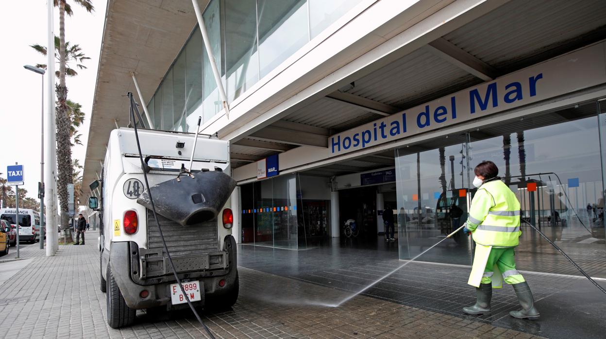 Empleados desinfectando la entrada del Hospital del Mar de Barcelona